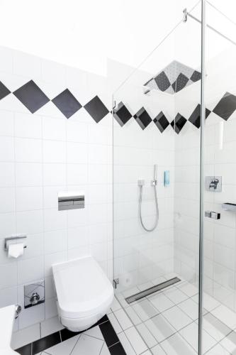 a white bathroom with a toilet and a shower at Schlosshotel Westerholt in Herten
