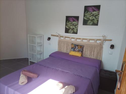 ein Schlafzimmer mit einem lila Bett und Hausschuhen darauf in der Unterkunft Spirit of Costa Calma in Costa Calma