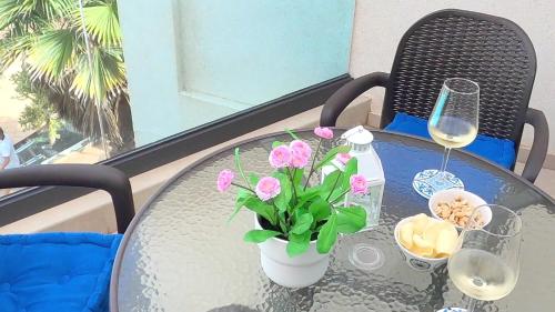 a glass table with a vase with pink flowers on it at El Cotillo Sonando/Stylish/Minutes from swim or surf/Well equipped in El Cotillo