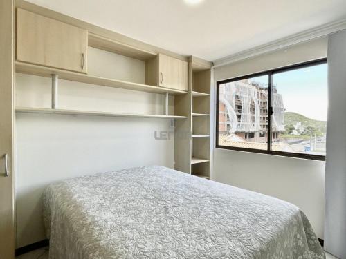 1 dormitorio con cama y ventana en 205 - Apartamento 02 dormitórios apenas 50m praia de Bombas, en Bombinhas