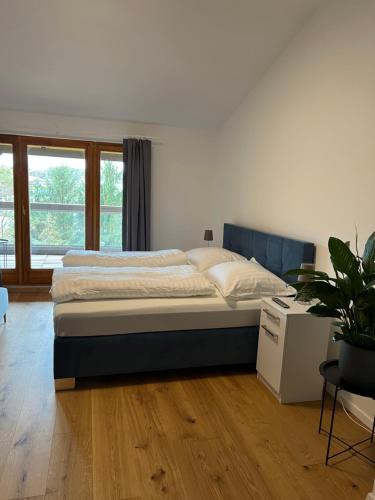 a bedroom with a bed and a potted plant at Pannonia Appartements in Bad Tatzmannsdorf
