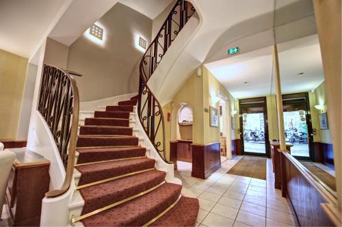 a winding staircase in a building with a lobby at Hôtel Du Midi Paris Montparnasse in Paris