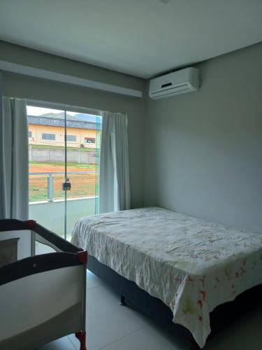 Schlafzimmer mit einem Bett und einem Fenster in der Unterkunft Casa Capitolio in Capitólio