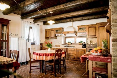 una cocina con mesa y sillas y una cocina con armarios de madera. en La Finestra sul Conero, en Castelfidardo