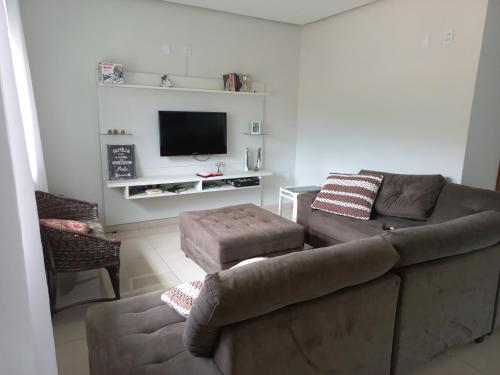 a living room with a couch and a tv at Casa Capitolio in Capitólio