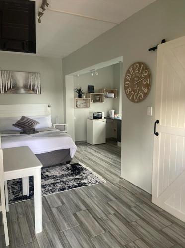 Un dormitorio con una cama y un reloj en la pared. en 22 on Mirabel, en Kempton Park