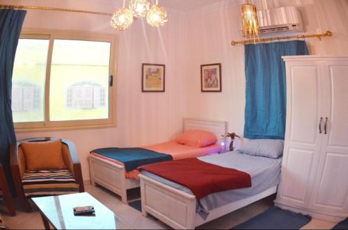 1 dormitorio con 2 camas individuales y ventana en Luna House Lighthouse en Dahab