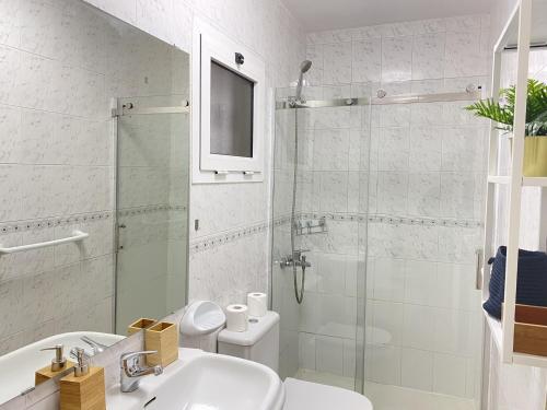 a bathroom with a shower and a sink and a toilet at HomeForGuest Two bedroom Apartment with pool and terrace in Caleta De Fuste