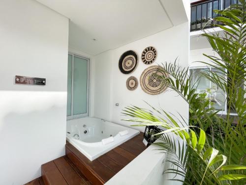 La salle de bains est pourvue d'une baignoire et de quelques plantes. dans l'établissement Mero Hotel Boutique, à Barra Grande