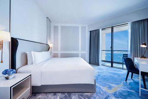 a hotel room with a bed and a desk and a desk at Sofitel Dubai Jumeirah Beach in Dubai