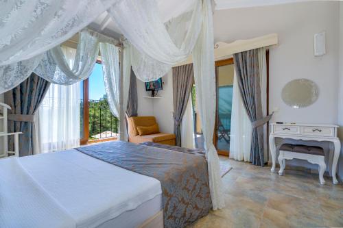 a bedroom with a bed and a chair and a window at Alya Villa Butik Hotel in Turunç