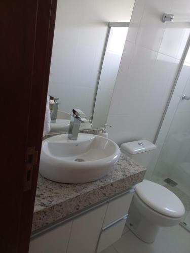 a white bathroom with a sink and a toilet at Casa Capitolio in Capitólio
