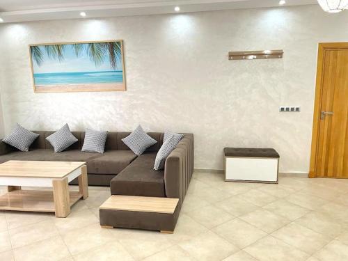 a living room with a couch and a table at Superbe Appartement avec Piscine - 5 min de la Plage à Imi Ouaddar in Imi Ouaddar