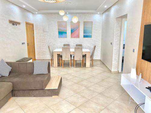 a living room with a couch and a table at Superbe Appartement avec Piscine - 5 min de la Plage à Imi Ouaddar in Imi Ouaddar
