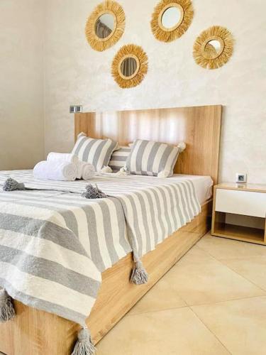 a bedroom with a large bed with mirrors on the wall at Superbe Appartement avec Piscine - 5 min de la Plage à Imi Ouaddar in Imi Ouaddar