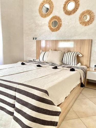 a bedroom with a large bed with black and white pillows at Superbe Appartement avec Piscine - 5 min de la Plage à Imi Ouaddar in Imi Ouaddar