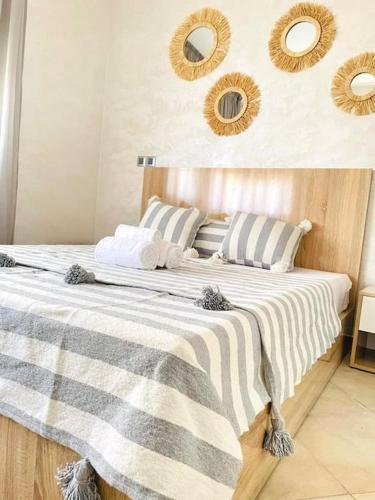 a bedroom with a large bed with mirrors on the wall at Superbe Appartement avec Piscine - 5 min de la Plage à Imi Ouaddar in Imi Ouaddar