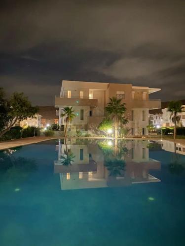 a house and a swimming pool at night at Superbe Appartement avec Piscine - 5 min de la Plage à Imi Ouaddar in Imi Ouaddar