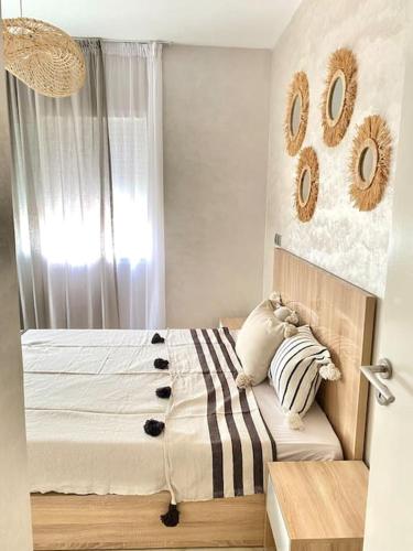 a bedroom with a bed and a window with numbers on the wall at Superbe Appartement avec Piscine - 5 min de la Plage à Imi Ouaddar in Imi Ouaddar