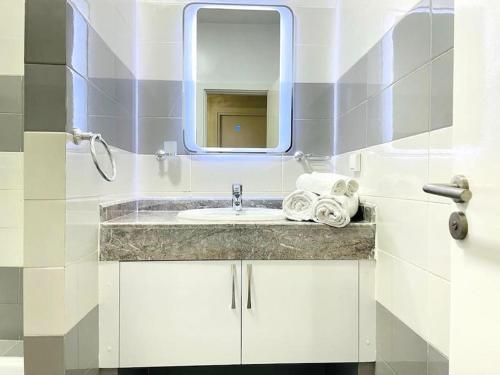 a bathroom with a sink and a mirror at Superbe Appartement avec Piscine - 5 min de la Plage à Imi Ouaddar in Imi Ouaddar