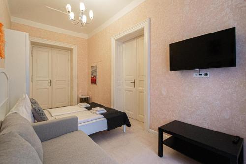 sala de estar con sofá y TV en la pared en Rose Ruterra Suite, en Praga