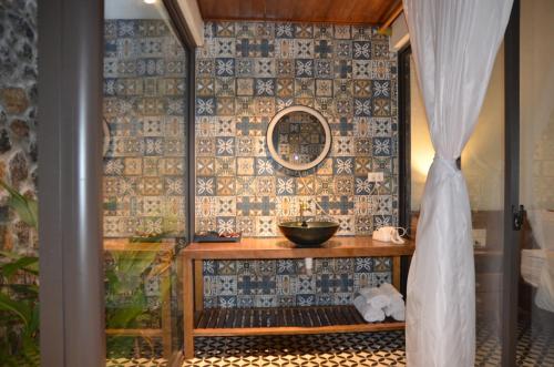 a bathroom with a table and a mirror on a wall at Hoa Và Đá Ninh Binh in Ninh Binh