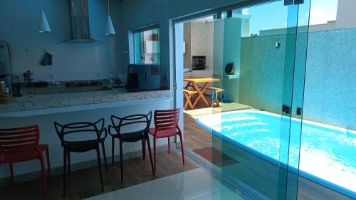 a kitchen with a bar with chairs and a swimming pool at Casa Capitolio in Capitólio