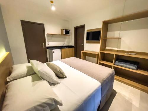 um quarto de hotel com uma cama e uma televisão em Hotel & Pousada Favareto em Florianópolis