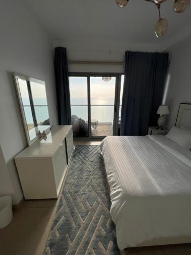 a bedroom with a bed and a view of the ocean at برج الجوهرة داماك in Jeddah