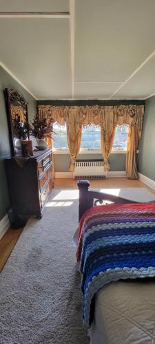 a bedroom with a bed and a window with curtains at TheGWMHouse 