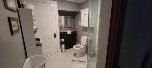 a small bathroom with a toilet and a glass door at TheGWMHouse 