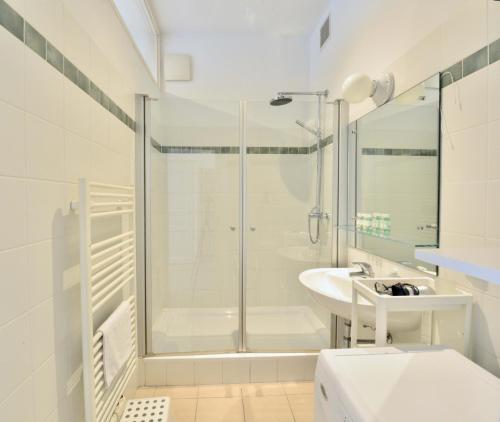 a white bathroom with a shower and a sink at Beautiful Flat Next to Karlskirche in Vienna