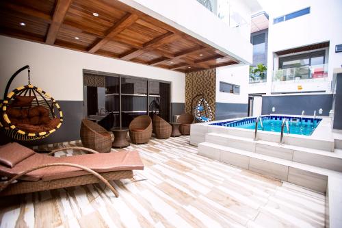 a pool room with chairs and a swimming pool at Rushmore - Standard Room in Lagos