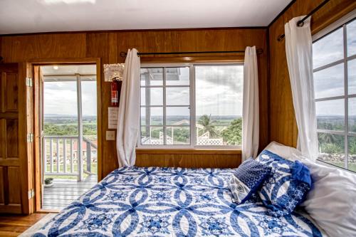 een slaapkamer met een bed en een groot raam bij Jehane Cabana at Bella Vue Estate in Georgeville