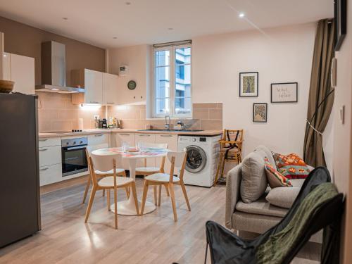 a kitchen and living room with a table and chairs at L'annexe Clermont Ferrand in Clermont-Ferrand