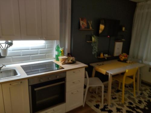 a small kitchen with a sink and a table at Apartman 7th Heaven in Zagreb