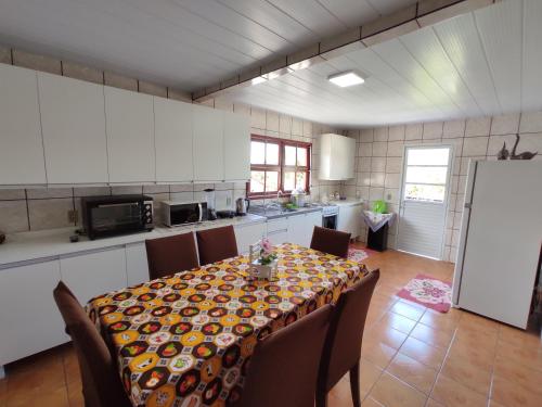 a kitchen with a table with chairs and a kitchen with a tableablish at Casa aconchegante a 4km-5min da Guarda do Embaú in Guarda do Embaú