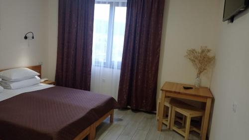 a bedroom with a bed and a window with curtains at MAFA Hotel in Bukovel