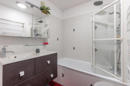 een badkamer met een bad, een wastafel en een douche bij Le Colibri - 3 chambres et balcon in Châtillon