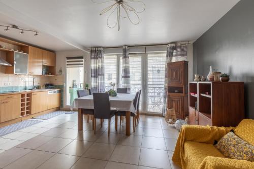 - une cuisine et une salle à manger avec une table et un canapé dans l'établissement Le Colibri - 3 chambres et balcon, à Châtillon