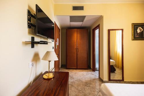 a living room with a couch and a table and a television at Apulia Hotel Taranto Ara Solis in Lido Azzurro