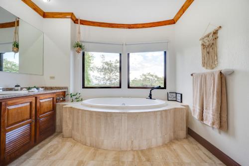 a large bathroom with a large tub and two windows at Casa Gerónimo in Playa Hermosa