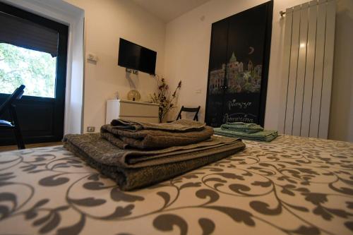 a bed with a pile of blankets on top of it at Dream House in Piazza Armerina