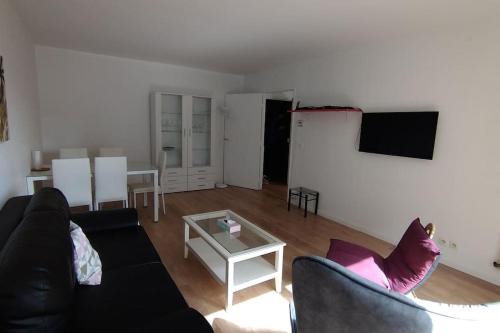 un salon avec un canapé noir et une table dans l'établissement La défense, 1 bedroom & 1 salon, 4 pers, à Courbevoie