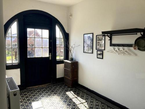 a hallway with a black door and a window at Winsen 1 Genieße kreative FeWo zw Hamburg u. Lüneburg in Winsen