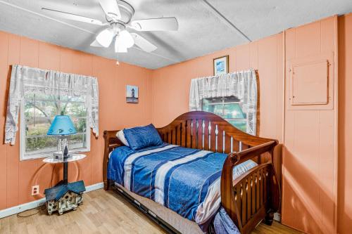 a bedroom with orange walls and a bed and a ceiling fan at Fanci's Hideout in Atlantic Beach