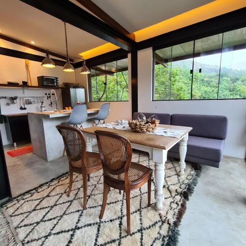 a kitchen and living room with a table and chairs at Vila Bambu Ilhabela, Santa Tereza in Ilhabela