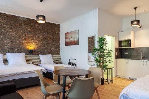 um quarto com duas camas e uma mesa e uma cozinha em Hotel Soers em Aachen