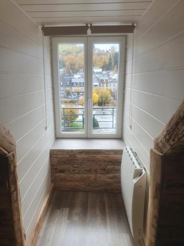 an empty bathroom with a window and a toilet at Bienvenue chez les ch'oups ' la ooh' in La Bourboule