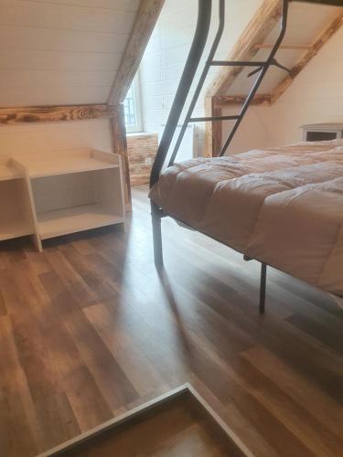 a bedroom with two bunk beds and a wooden floor at Bienvenue chez les ch'oups ' la ooh' in La Bourboule